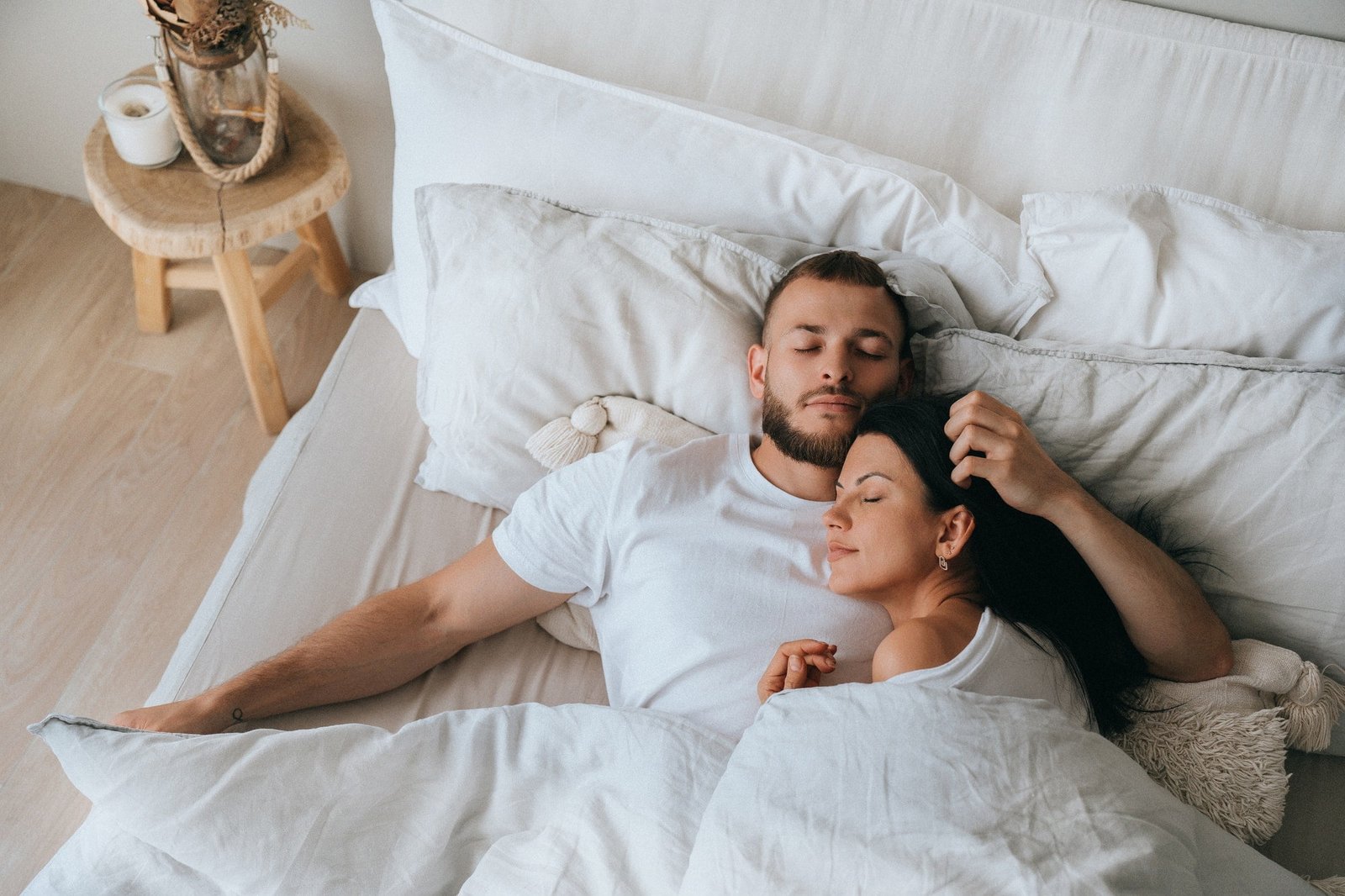Young caucasian sleeping couple in bed. Handsome beardy European man laying with wife